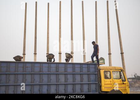 Les travailleurs de jour déchargent le charbon d'un cargo à Gabtoli, Dhaka, sur 3 février 2021. Les travailleurs gagnent en moyenne environ 1 USD par jour pour leur travail acharné. (Photo d'Ahmed Salahuddin/NurPhoto) Banque D'Images