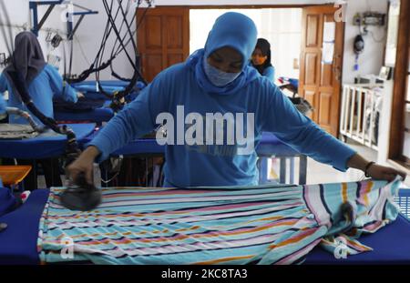 Un employé est vu fer blanchisserie à Bogor Blanchisserie à Bogor, Java Ouest sur 6 février 2021. Bogor's Laundry est un service commercial de blanchisserie pour les hôtels, les industriels, la maison. La pandémie COVID-19 a affecté le secteur de la lessive dans les économies nationale et mondiale est sans précédent. (Photo par Adriana Adie/NurPhoto) Banque D'Images