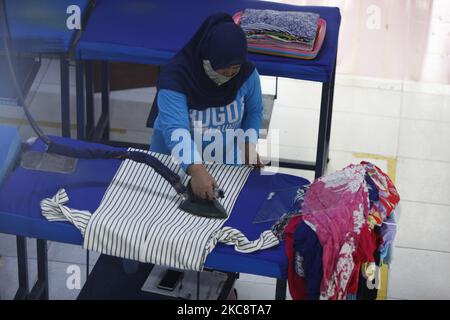 Un employé est vu fer blanchisserie à Bogor Blanchisserie à Bogor, Java Ouest sur 6 février 2021. Bogor's Laundry est un service commercial de blanchisserie pour les hôtels, les industriels, la maison. La pandémie COVID-19 a affecté le secteur de la lessive dans les économies nationale et mondiale est sans précédent. (Photo par Adriana Adie/NurPhoto) Banque D'Images