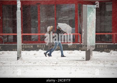 Personnes tenant un parapluie pendant la chute de neige pour se protéger. Blizzard de la tempête de neige Darcy aux pays-Bas, la première chute de neige lourde avec des vents forts intenses après 2010 perturber le transport dans tout le pays. Les Hollandais se sont réveillés dimanche avec une couche de neige couvrant tout. De nombreux accidents se sont produits sur les routes en raison de la tempête et de la verglas, alors qu'il y avait également des problèmes avec les trains. Dans la ville d'Eindhoven, au nord du Brabant, les services de train et d'autobus ont cessé leurs activités, l'aéroport a suivi et le trafic aérien a été détourné. Les gens sont allés dehors dans le centre-ville de E Banque D'Images