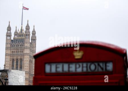 Un drapeau de l'Union Jack vole en neige depuis le sommet de la tour Victoria des chambres du Parlement, au-dessus d'un téléphone rouge traditionnel sur Whitehall à Londres, en Angleterre, sur 9 février 2021. Le Royaume-Uni continue de ressentir les effets du temps froid de Storm Darcy, qui a apporté plusieurs jours de neige et des conditions inférieures à zéro au pays. (Photo de David Cliff/NurPhoto) Banque D'Images