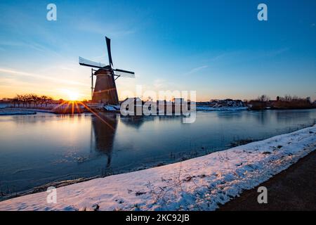 La magie de la sellerie autour de l'heure du coucher du soleil et de la tombée de la nuit avec ciel d'hiver clair sur les canaux gelés et les moulins à vent de Kinderdijk aux pays-Bas. Le pays est confronté à des conditions météorologiques arctiques, à des températures très basses, à des chutes de neige et à des vents violents en raison de la tempête Darcy qui a causé des problèmes dans les transports et dans la vie quotidienne. Beaucoup de canaux ont été gelés sous forme de glace car il y a une température inférieure à zéro du temps froid atteignant parfois -16C, alors que la terre est couverte de neige. Kinderdijk et les moulins à vent dans le polder d'Alblasserwaard, est une attraction célèbre, un monument hollandais et un site classé au patrimoine mondial de l'UNESCO, attint Banque D'Images