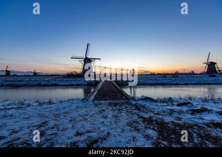 La magie de la sellerie autour de l'heure du coucher du soleil et de la tombée de la nuit avec ciel d'hiver clair sur les canaux gelés et les moulins à vent de Kinderdijk aux pays-Bas. Le pays est confronté à des conditions météorologiques arctiques, à des températures très basses, à des chutes de neige et à des vents violents en raison de la tempête Darcy qui a causé des problèmes dans les transports et dans la vie quotidienne. Beaucoup de canaux ont été gelés sous forme de glace car il y a une température inférieure à zéro du temps froid atteignant parfois -16C, alors que la terre est couverte de neige. Kinderdijk et les moulins à vent dans le polder d'Alblasserwaard, est une attraction célèbre, un monument hollandais et un site classé au patrimoine mondial de l'UNESCO, attint Banque D'Images