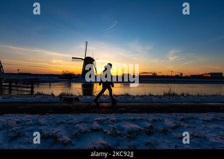 La magie de la sellerie autour de l'heure du coucher du soleil et de la tombée de la nuit avec ciel d'hiver clair sur les canaux gelés et les moulins à vent de Kinderdijk aux pays-Bas. Le pays est confronté à des conditions météorologiques arctiques, à des températures très basses, à des chutes de neige et à des vents violents en raison de la tempête Darcy qui a causé des problèmes dans les transports et dans la vie quotidienne. Beaucoup de canaux ont été gelés sous forme de glace car il y a une température inférieure à zéro du temps froid atteignant parfois -16C, alors que la terre est couverte de neige. Kinderdijk et les moulins à vent dans le polder d'Alblasserwaard, est une attraction célèbre, un monument hollandais et un site classé au patrimoine mondial de l'UNESCO, attint Banque D'Images