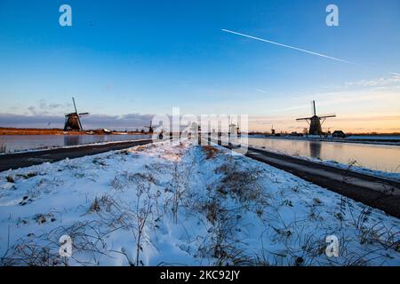 La magie de la sellerie autour de l'heure du coucher du soleil et de la tombée de la nuit avec ciel d'hiver clair sur les canaux gelés et les moulins à vent de Kinderdijk aux pays-Bas. Le pays est confronté à des conditions météorologiques arctiques, à des températures très basses, à des chutes de neige et à des vents violents en raison de la tempête Darcy qui a causé des problèmes dans les transports et dans la vie quotidienne. Beaucoup de canaux ont été gelés sous forme de glace car il y a une température inférieure à zéro du temps froid atteignant parfois -16C, alors que la terre est couverte de neige. Kinderdijk et les moulins à vent dans le polder d'Alblasserwaard, est une attraction célèbre, un monument hollandais et un site classé au patrimoine mondial de l'UNESCO, attint Banque D'Images