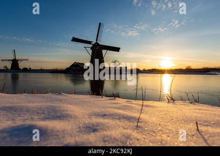 La magie de la sellerie autour de l'heure du coucher du soleil et de la tombée de la nuit avec ciel d'hiver clair sur les canaux gelés et les moulins à vent de Kinderdijk aux pays-Bas. Le pays est confronté à des conditions météorologiques arctiques, à des températures très basses, à des chutes de neige et à des vents violents en raison de la tempête Darcy qui a causé des problèmes dans les transports et dans la vie quotidienne. Beaucoup de canaux ont été gelés sous forme de glace car il y a une température inférieure à zéro du temps froid atteignant parfois -16C, alors que la terre est couverte de neige. Kinderdijk et les moulins à vent dans le polder d'Alblasserwaard, est une attraction célèbre, un monument hollandais et un site classé au patrimoine mondial de l'UNESCO, attint Banque D'Images