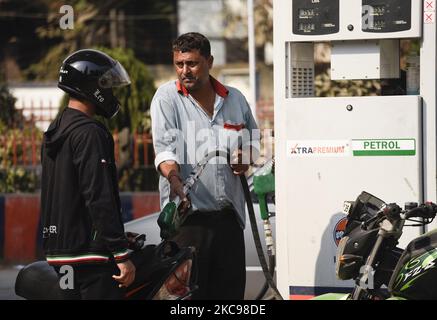 Les gens qui font le plein d'essence et de carburant diesel dans leurs véhicules dans une station-service de 13 février 2021 à Guwahati, en Inde. Avant les élections d'assemblée, le gouvernement d'Assam a décidé de réduire les prix de l'essence et du diesel à Assam de 5 roupies le litre à partir de vendredi minuit, faisant des carburants l'un des moins coûteux du pays. Le gouvernement d'Assam a supprimé l'impôt supplémentaire de RS 5 prélevé l'an dernier sur l'essence et le diesel au pic de la pandémie de Covid-19. (Photo de David Talukdar/NurPhoto) Banque D'Images