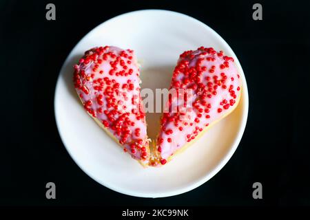 Un donut en forme de coeur coupé en deux morceaux est représenté comme une illustration de la Saint-Valentin. Cracovie, Pologne sur 14 février 2021. (Photo de Beata Zawrzel/NurPhoto) Banque D'Images