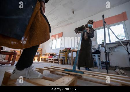 Les femmes palestiniennes travaillent à leur atelier de menuiserie dans le village d'Al-Walajah, près de la ville de Bethléem, en Cisjordanie, le 14 février 2021. Il y a cinq ans, sept femmes au foyer palestiniennes ont lancé leur propre projet de recyclage du bois pour gagner leur vie, transformant le bois de rebut en produits utilisables, qui ont été vendus aux boutiques de souvenirs et sur les réseaux sociaux. (Photo de Luay Sababa/NurPhoto) Banque D'Images