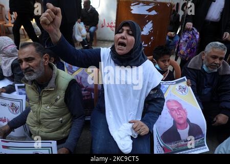 Les familles palestiniennes de martyrs et de woundeds portant un masque facial protecteur, lorsqu'elles prennent part à une manifestation pour exiger leurs droits et leurs salaires, devant le siège de la Fondation martyrs et blessés, dans la ville de Gaza, sur 16 février 2021. Les élections représenteraient un risque majeur pour le parti Fatah d'Abbas et aussi pour le Hamas, qui a accueilli favorablement le décret. Ces dernières années, les deux pays ont été confrontés à des manifestations pour leur incapacité à se réconcilier, à faire progresser les aspirations palestiniennes à la création d'un État ou à répondre aux besoins fondamentaux de ceux qui se trouvent dans les territoires qu'ils gouvernent. (Photo de Majdi Fathi/NurPhoto) Banque D'Images