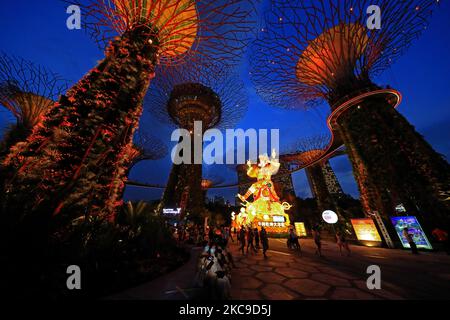 Les gens regardent une exposition de lanternes géantes mettant en vedette le God of Fortune pendant le festival de la rivière Hongbao au Supertree Grove, jardins près de la baie de 16 février 2021 à Singapour. Organisé chaque année depuis 1987, ce festival fait partie des célébrations du nouvel an lunaire de Singapour pour les habitants de la région comme pour les touristes. En raison de la pandémie actuelle de COVID-19 et afin de réduire le surpeuplement, l'organisateur a imposé une capacité de participation limitée et un créneau horaire pour chaque visiteur. (Photo de Suhaimi Abdullah/NurPhoto) Banque D'Images