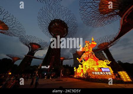 Les gens regardent une exposition de lanternes géantes mettant en vedette le God of Fortune pendant le festival de la rivière Hongbao au Supertree Grove, jardins près de la baie de 16 février 2021 à Singapour. Organisé chaque année depuis 1987, ce festival fait partie des célébrations du nouvel an lunaire de Singapour pour les habitants de la région comme pour les touristes. En raison de la pandémie actuelle de COVID-19 et afin de réduire le surpeuplement, l'organisateur a imposé une capacité de participation limitée et un créneau horaire pour chaque visiteur. (Photo de Suhaimi Abdullah/NurPhoto) Banque D'Images