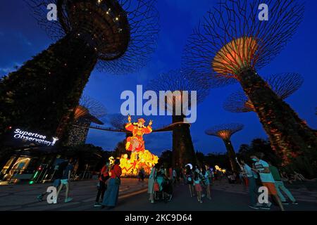 Les gens regardent une exposition de lanternes géantes mettant en vedette le God of Fortune pendant le festival de la rivière Hongbao au Supertree Grove, jardins près de la baie de 16 février 2021 à Singapour. Organisé chaque année depuis 1987, ce festival fait partie des célébrations du nouvel an lunaire de Singapour pour les habitants de la région comme pour les touristes. En raison de la pandémie actuelle de COVID-19 et afin de réduire le surpeuplement, l'organisateur a imposé une capacité de participation limitée et un créneau horaire pour chaque visiteur. (Photo de Suhaimi Abdullah/NurPhoto) Banque D'Images