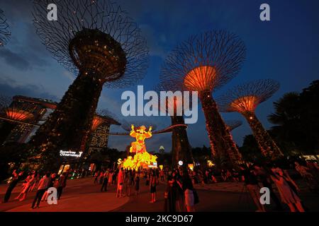 Les gens regardent une exposition de lanternes géantes mettant en vedette le God of Fortune pendant le festival de la rivière Hongbao au Supertree Grove, jardins près de la baie de 16 février 2021 à Singapour. Organisé chaque année depuis 1987, ce festival fait partie des célébrations du nouvel an lunaire de Singapour pour les habitants de la région comme pour les touristes. En raison de la pandémie actuelle de COVID-19 et afin de réduire le surpeuplement, l'organisateur a imposé une capacité de participation limitée et un créneau horaire pour chaque visiteur. (Photo de Suhaimi Abdullah/NurPhoto) Banque D'Images