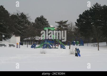 Garçon porte un toboggan dans un petit parc après une tempête de neige qui a laissé tomber près de 25 centimètres de neige dans la ville de Toronto, Ontario, Canada, sur 16 février 2021. (Photo de Creative Touch Imaging Ltd./NurPhoto) Banque D'Images