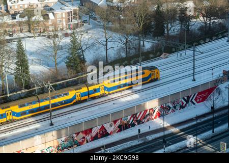 Un train sur les pistes enneigées du centre-ville. Vue d'ensemble panoramique de la neige a couvert la ville néerlandaise d'Eindhoven comme vu dans le centre et les zones résidentielles, tandis que la neige a couvert les routes, les chemins de fer, les toits pendant une période de plus d'une semaine entraînant également le gel des lacs et des canaux. Eindhoven, pays-Bas, le 2021 février (photo de Nicolas Economou/NurPhoto) Banque D'Images