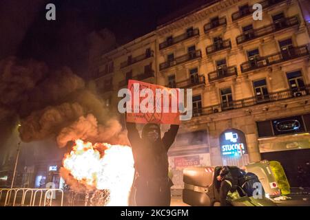 Le manifestant est vu devant un contenant en feu avec une bannière qui lit, nazi à la prison, ennemi est fasciste deuxième nuit de manifestations, à Barcelone, pour la prison du rappeur catalan, Pablo Hasél, arrêté mardi, 16 février et condamné à neuf mois et un jour de prison par la Chambre d'appel de la Cour nationale en septembre 2018, ainsi que le paiement d'une amende d'environ 30 000 euros accusé de glorifier le terrorisme, insulter et calomnier la monarchie et les forces de sécurité de l'état. (Photo par DAX Images/NurPhoto) Banque D'Images