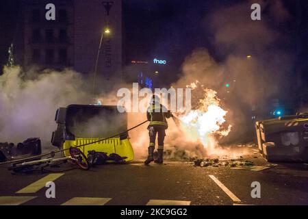 Un pompier a vu éteindre des incendies de conteneurs d'ordures la deuxième nuit de manifestations, à Barcelone, pour la prison du rappeur catalan, Pablo Hasél, arrêtée mardi, 16 février et condamnée à neuf mois et un jour de prison par la Chambre d'appel de la Cour nationale en septembre 2018, ainsi que le paiement d'une amende d'environ 30 000 euros accusé de glorifier le terrorisme, d'insulter et d'offenser la monarchie et les forces de sécurité de l'état. (Photo par DAX Images/NurPhoto) Banque D'Images