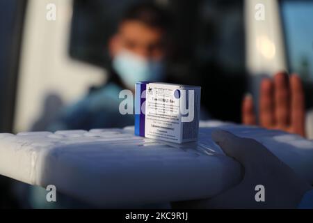 Un agent de santé palestinien porte une boîte de doses de vaccin Spoutnik V de marque russe provenant des Émirats arabes Unis, à l'arrivée d'une charge de camions dans la bande de Gaza via le passage de Rafah avec l'Égypte, sur 21 février 2021. - Environ 20 000 doses de vaccin contre le coronavirus en provenance des Émirats arabes Unis sont arrivées aujourd'hui à Gaza, une livraison aurait été orchestrée par un rival du président palestinien Mahmud Abbas trois mois avant la tenue des élections palestiniennes. (Photo de Majdi Fathi/NurPhoto) Banque D'Images