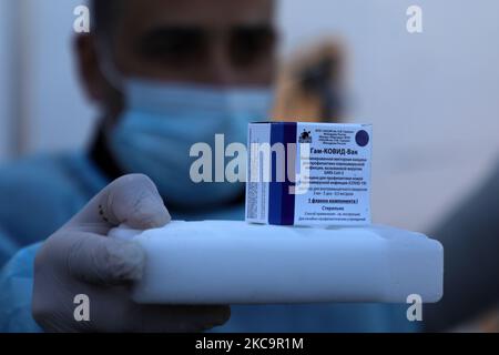 Un agent de santé palestinien porte une boîte de doses de vaccin Spoutnik V de marque russe provenant des Émirats arabes Unis, à l'arrivée d'une charge de camions dans la bande de Gaza via le passage de Rafah avec l'Égypte, sur 21 février 2021. - Environ 20 000 doses de vaccin contre le coronavirus en provenance des Émirats arabes Unis sont arrivées aujourd'hui à Gaza, une livraison aurait été orchestrée par un rival du président palestinien Mahmud Abbas trois mois avant la tenue des élections palestiniennes. (Photo de Majdi Fathi/NurPhoto) Banque D'Images