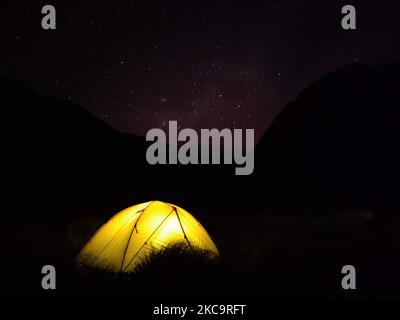 Tente jaune sous le ciel nocturne avec la voie laiteuse et la croix sud en arrière-plan Banque D'Images