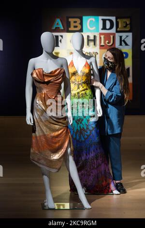 Un membre du personnel de la galerie pose avec Gold Label Sechinned Diamond Jubilee corset Gown, 2012, par Vivienne Westwood (est. £1 200-1 800), (à gauche) et Birds of Paradise Gown, 2008, par Alexander McQueen (est. £1 500-2 000) (à droite) lors d'un appel photo pour Bonhams British. Cool. Vente mettant en vedette une gamme variée de talents britanniques et émigrés des cent dernières années, sur 22 février 2021 à Londres, Angleterre. (Photo de Wiktor Szymanowicz/NurPhoto) Banque D'Images