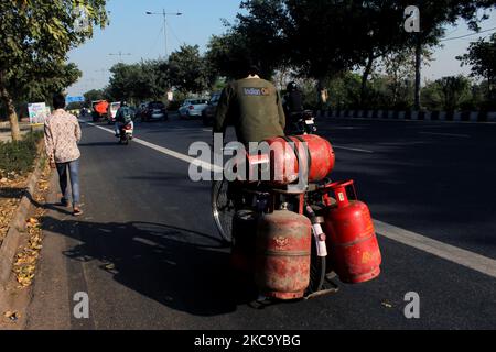 Un liveur, transportant des bouteilles de gaz de pétrole liquéfié (GPL), fait son vélo à New Delhi, en Inde, sur 20 février 2021. Les prix du gaz de pétrole liquéfié (GPL) non subventionné ont été pris en charge par ? 50 dans la capitale nationale sur 14 février. Selon les nouveaux tarifs, une bouteille de gaz de 14,2 kg à Delhi coûte maintenant ? 769 (pour les bouteilles non subventionnées) à partir de 15 février (12 heures du matin). (Photo de Mayank Makhija/NurPhoto) Banque D'Images