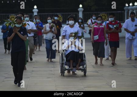 Les personnes qui tiennent des fleurs, des bâtons de jos et des bougies illuminées pour des prières marchent dans un cercle de procession autour du monastère pour marquer la journée de Makha Bucha au temple de Wat Asokaram dans la province de Samut Prakan, Thaïlande, 26 février 2021. (Photo par Anusak Laowilas/NurPhoto) Banque D'Images