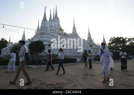 Les personnes qui tiennent des fleurs, des bâtons de jos et des bougies illuminées pour des prières marchent dans un cercle de procession autour du monastère pour marquer la journée de Makha Bucha au temple de Wat Asokaram dans la province de Samut Prakan, Thaïlande, 26 février 2021. (Photo par Anusak Laowilas/NurPhoto) Banque D'Images