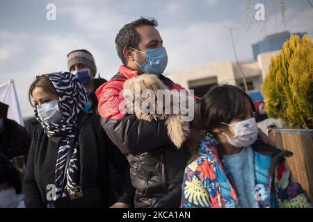 Un iranien portant un masque facial protecteur portant son animal tout en faisant des emplettes dans le marché de Parvaneh, dans le centre de Téhéran, dans le contexte de la nouvelle épidémie de coronavirus (COVID-19) en Iran, sur 26 février 2021. Les autorités iraniennes ont averti les gens que le pays est sur le point de connaître la quatrième vague de l'épidémie de COVID-19 et cela se produira si les gens ne sont pas en mesure de respecter les protocoles de santé, de prendre des distances sociales et d'arrêter de voyager dans les autres villes. (Photo de Morteza Nikoubazl/NurPhoto) Banque D'Images