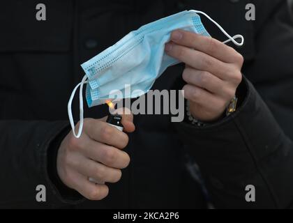 Un manifestant anti-Lockdown brûle un masque facial lors d'une manifestation dans le centre-ville de Dublin, pendant le confinement de Covid-19 de niveau 5. Samedi, 27 février 2021, à Dublin, Irlande. (Photo par Artur Widak/NurPhoto) Banque D'Images