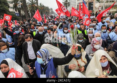 Les partisans d'Ennahda lèvent des roses alors qu'ils branle les drapeaux de la Tunisie lors d'une manifestation organisée par le parti islamiste d'Ennahda sur l'avenue Mohammed V dans la capitale Tunis, Tunisie, sur 27 février 2021, En faveur de la « légitimité » du Parlement et du gouvernement du premier ministre Hichem Machichi et pour protester contre le rejet par le président Kais Saied du remaniement de Mechichi et pour « protéger la démocratie ». (Photo de Chedly Ben Ibrahim/NurPhoto) Banque D'Images