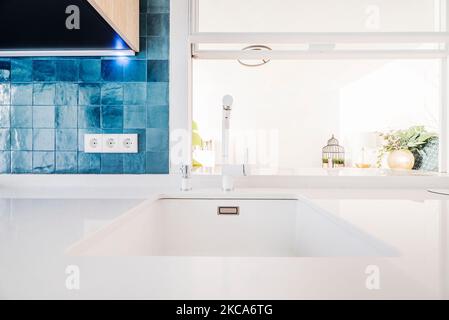 Coin cuisine avec comptoir en pierre blanche avec évier intégré et carrelage bleu cobalt brillant Banque D'Images