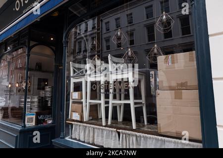 LONDRES, ROYAUME-UNI - 02 MARS 2021 : les fûts, les boîtes et les chaises sont empilés contre une fenêtre d'un restaurant d'huîtres dans le centre de Londres, alors que l'Angleterre reste sous le troisième confinement pour réduire le nombre d'infections Covid-19, le 02 mars 2021 à Londres, en Angleterre. Le chancelier Rishi Sunak doit annoncer ses plans d'impôts et de dépenses dans le budget 2021 de demain, en mettant l'accent sur les mesures visant à soutenir la reprise économique du Royaume-Uni après la crise provoquée par la pandémie du coronavirus, y compris un programme de 5bn livres sterling pour les magasins et les entreprises d'accueil de High Street ainsi que 408m £ pour les musées, théâtres et galeries. (P Banque D'Images