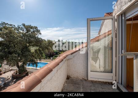 Petite terrasse vide d'une maison unifamiliale entourée de carreaux et de portes en aluminium et en verre Banque D'Images