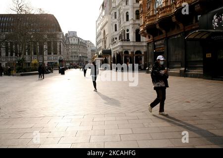 Les gens marchent devant des cinémas fermés, des casinos et des restaurants dans un Leicester Square proche de désert à Londres, Angleterre, sur 8 mars 2021. Aujourd'hui a marqué la première étape de l'assouplissement du confinement des coronavirus dans toute l'Angleterre, avec la réouverture des écoles et quelques limites sur les contacts sociaux assouplies. Les magasins, bars, restaurants et autres commerces d'accueil non essentiels restent toutefois fermés et ne rouvriront pas avant le mois prochain selon les horaires en vigueur. (Photo de David Cliff/NurPhoto) Banque D'Images