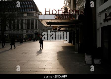 Un homme passe devant des cinémas fermés, des casinos et des restaurants dans une place de Leicester à Londres, en Angleterre, sur 8 mars 2021. Aujourd'hui a marqué la première étape de l'assouplissement du confinement des coronavirus dans toute l'Angleterre, avec la réouverture des écoles et quelques limites sur les contacts sociaux assouplies. Les magasins, bars, restaurants et autres commerces d'accueil non essentiels restent toutefois fermés et ne rouvriront pas avant le mois prochain selon les horaires en vigueur. (Photo de David Cliff/NurPhoto) Banque D'Images