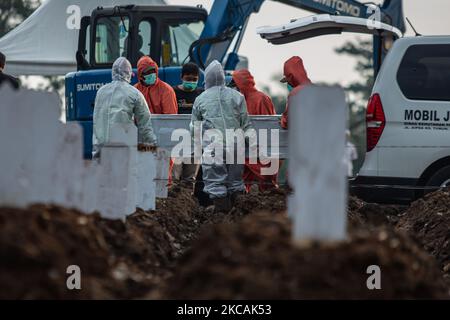 Des creuseurs de tombes enterrent un cercueil d'un coronavirus Covid-19 victime dans un cimetière spécial de Jakarta sur 9 mars 2021. (Photo par Afriadi Hikmal/NurPhoto) Banque D'Images