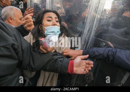 Une protestante de mouvements islamistes scanne des slogans alors qu'elle se moque des forces de sécurité qui tiennent des boucliers, lors d'une manifestation organisée devant le siège de la branche tunisienne de l'Union internationale des boursiers musulmans (IUMS) dans la capitale Tunis, Tunisie, sur 10 mars 2021, Pour protester contre le président du Parti du destin libre (PDL), Abir Moussi et ses partisans, qui tiennent un sit-in à l'extérieur du siège de l'IUMS pour en appeler à sa dissolution. (Photo de Chedly Ben Ibrahim/NurPhoto) Banque D'Images