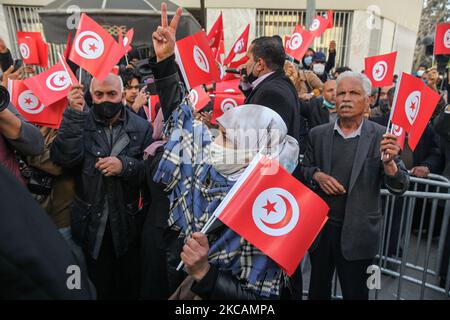 Une manifestante de mouvements islamistes lève le drapeau de la Tunisie alors qu'elle signe la victoire, lors d'une manifestation organisée devant le siège de la branche tunisienne de l'Union internationale des boursiers musulmans (IUMS) dans la capitale Tunis, Tunisie, sur 10 mars 2021, Pour protester contre le président du Parti du destin libre (PDL), Abir Moussi et ses partisans, qui tiennent un sit-in à l'extérieur du siège de l'IUMS pour en appeler à sa dissolution. (Photo de Chedly Ben Ibrahim/NurPhoto) Banque D'Images