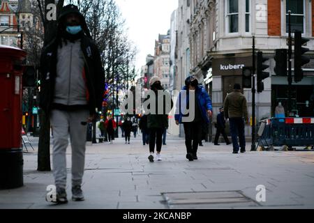 Des personnes portant un masque facial se promo le long d'une rue Oxford presque déserte à Londres, en Angleterre, sur 11 mars 2021. Cette semaine a marqué la première étape de l'assouplissement du confinement des coronavirus dans toute l'Angleterre, avec la réouverture des écoles et quelques limites sur les contacts sociaux assouplies. Les magasins, bars, restaurants et autres commerces d'accueil et de loisirs non essentiels restent toutefois fermés et ne rouvriront pas avant le mois prochain selon les horaires en vigueur. (Photo de David Cliff/NurPhoto) Banque D'Images