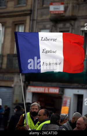 Un manifestant affiche un drapeau de Fench indiquant « liberté, égalité, Fraternité ». Les manifestants ont protesté contre le projet de loi sur la sécurité mondiale promu par le président français Macron et sa majorité. La manifestation a été organisée par plusieurs ONG comme Amnesty International, la Human Rights League et plusieurs syndicats (FO, SNJ [Union nationale des journalistes], CNT, etc.) Le projet de loi sur la sécurité mondiale interdit à quiconque de photographier ou de filmer des membres de la police s'il n'est pas bafoué : les transgresseurs pourraient être condamnés jusqu'à un an de prison et une amende de €45,000. Le projet de loi prévoit également de généraliser la reconnaissance faciale dans le spa pubien Banque D'Images