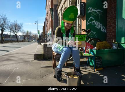 Une femme portant un chapeau de Saint Patrick épluche les pommes de terre à l'extérieur du restaurant Irish Potato Cake Company, dans le centre-ville de Dublin, le jour de la Saint-Patrick. Le mercredi 17 mars 2021, à Dublin, Irlande. (Photo par Artur Widak/NurPhoto) Banque D'Images