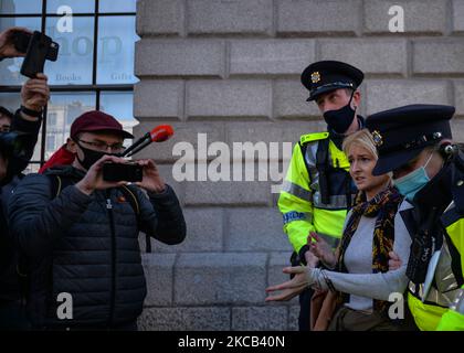 Des membres de Garda Siochana (police irlandaise) ont arrêté une jeune femme devant le bureau de poste général, alors que des manifestants anti-verrouillage manifestent le jour de la Saint-Patrick dans le centre-ville de Dublin. Le mercredi 17 mars 2021, à Dublin, Irlande. (Photo par Artur Widak/NurPhoto) Banque D'Images