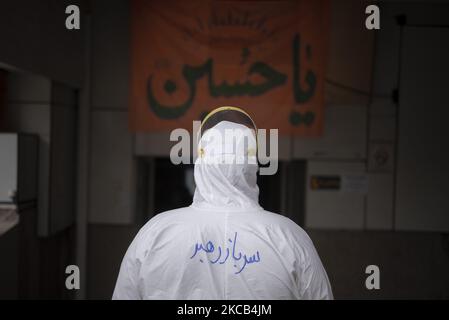 Un religieux djihadiste iranien-arabe portant un costume de protection pose une photo comme un script perse vu sur le dos qui se lit, soldat de leader, dans un département de COVID-19 de l'hôpital d'enseignement de Razi dans la ville d'Ahvaz à 817Km (508 miles) au sud de Téhéran dans la province de Khouzestan sur 16 mars, 2021. (Photo de Morteza Nikoubazl/NurPhoto) Banque D'Images