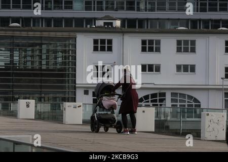 Une mère solitaire pousse la calèche avec son enfant à travers le pont Medienhafen au-dessus du Rhin à Düsseldorf, Allemagne, 18 mars 2021. (Photo par Sergii Kharchenko/NurPhoto) Banque D'Images