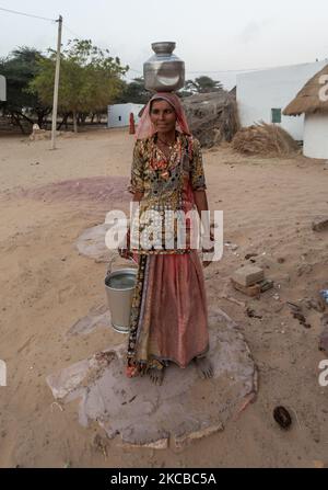 Avec moins de précipitations et d'eau à la rare dans la région aride du désert de Thar, une femme indienne avec l'eau recueillie d'un réservoir d'eau récolté au village de Godu, à environ 200 kms de la ville la plus proche de Bikaner, Rajasthan, Inde sur 22 mars 2021. Chaque année, 22 mars est célébrée comme la journée mondiale de l'eau. (Photo par Partha Hazarika/NurPhoto) Banque D'Images