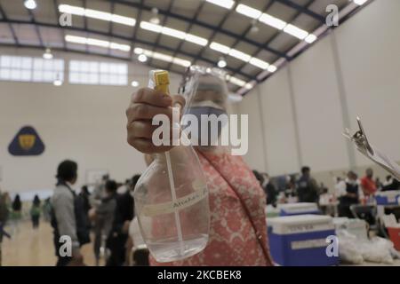 Un adulte plus âgé tient un récipient contenant de l'alcool après avoir été immunisé avec le produit biologique Sinovac à l'intérieur des installations de l'école préparatoire nationale n° 5 José Vasconcelos de l'Université nationale autonome du Mexique, situé dans le district de Tlalpan de Mexico, Pendant l'urgence sanitaire COVID-19 et le feu de circulation épidémiologique orange dans la capitale. (Photo de Gerardo Vieyra/NurPhoto) Banque D'Images