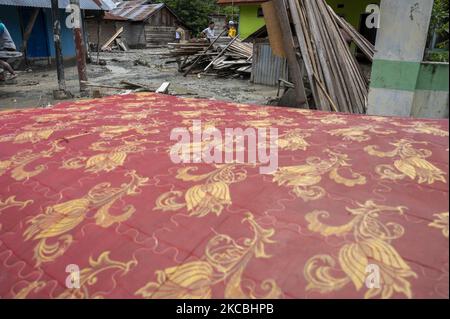 Les résidents et les bénévoles ont nettoyé la boue restante qui a frappé les maisons du village de Beka, district de Marawola, régence de Sigi, province centrale de Sulawesi, Indonésie sur 27 mars 2021. Les crues de boue qui se sont produites à 26 mars 2021 cette nuit-là ont été causées par de fortes pluies qui ont causé des glissements de terrain dans les montagnes et ont balayé les colonies dans cette région. Il n'y a pas eu de victimes dans l'incident, mais au moins 70 maisons ont été gravement endommagées, plus de 100 maisons ont été légèrement endommagées et inondées de boue, et environ 200 résidents ont dû être évacués. (Photo de Basri Marzuki/NurPhoto) Banque D'Images