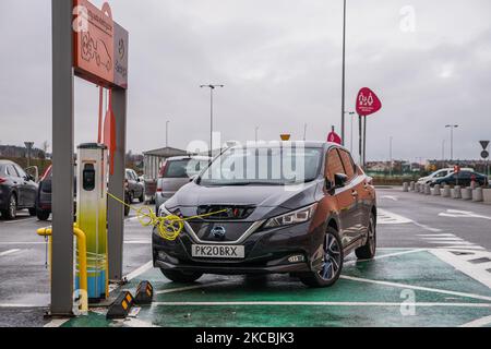 Nissan Leaf à une station de charge EV connectée à la prise est vu à Gdansk, Pologne le 15 mars 2021 (photo de Michal Fludra/NurPhoto) Banque D'Images
